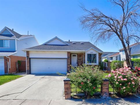 Brick facade residence featuring a front-facing garage with a white door, a bay window, a small fron